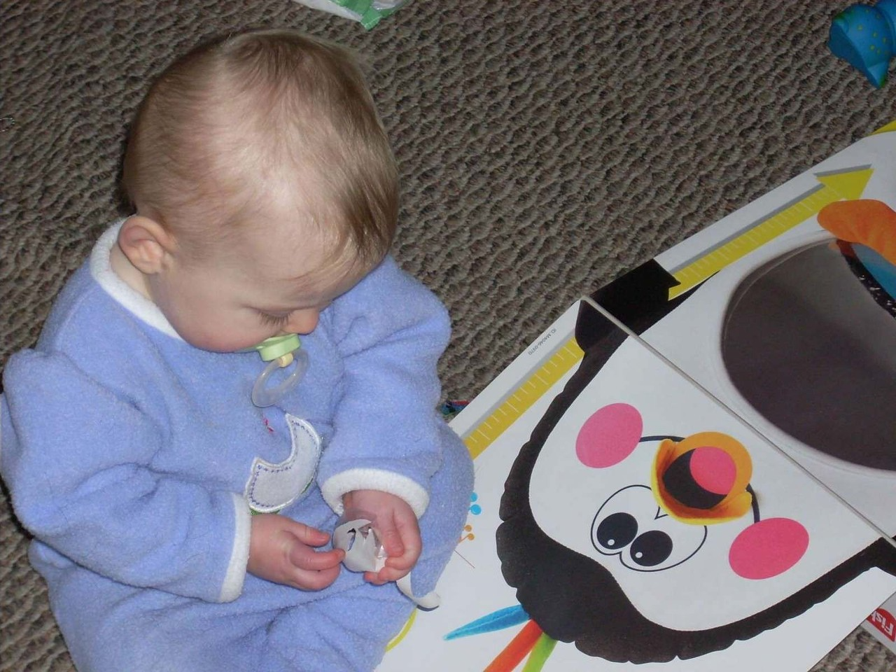 Author photo of baby's First Christmas. Sitting by a present.